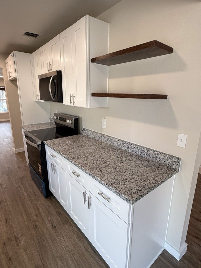 White shaker cabinets with floating wood shelves